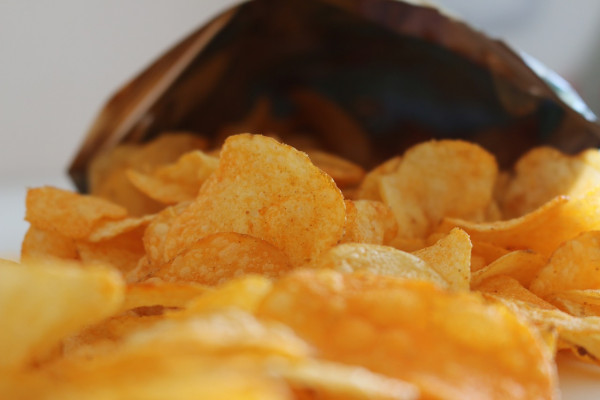 Potato crisps spilling out of a bag.