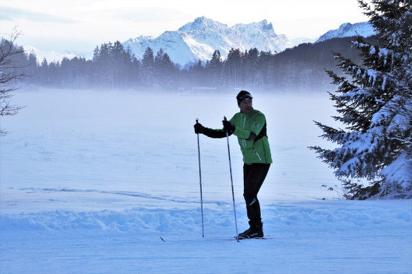 A skier stands on a frosty ski slope.