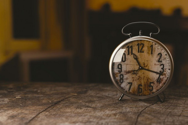 an old style alarm clock, faded with time