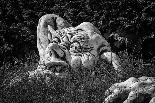 A statue of a trolls head in grass