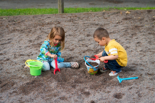 Two young children playing in the sand.