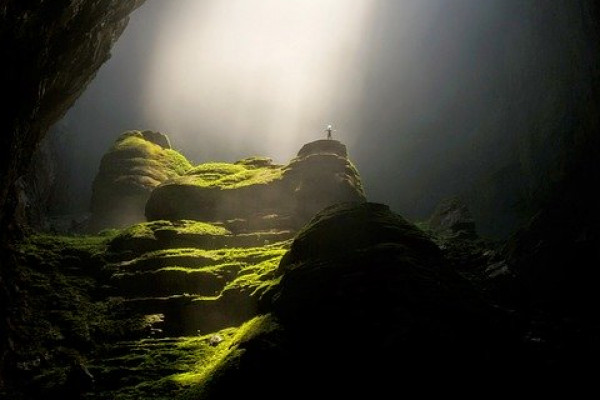 A cave arch with light coming through the ceiling on the other side