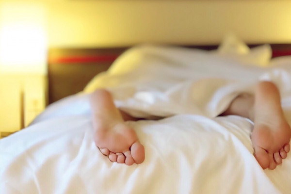 Feet of a sleeping person in bed