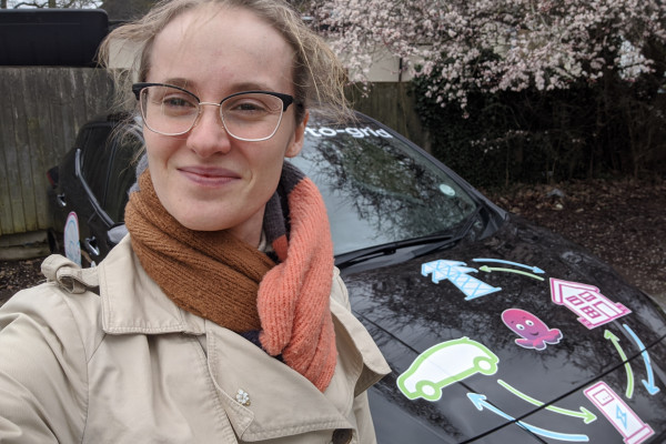 Megan McGregor, a Naked Scientists intern, standing in front of a Nissan Leaf