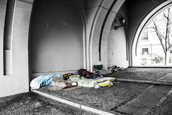 Beds of homeless people under an archway