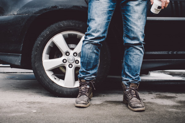 Person wearing jeans standing next to a car