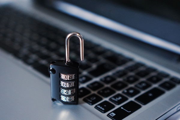 The image shows a laptop with an open padlock.