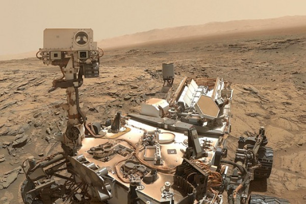 The image shows a robotic rover on the surface of Mars.