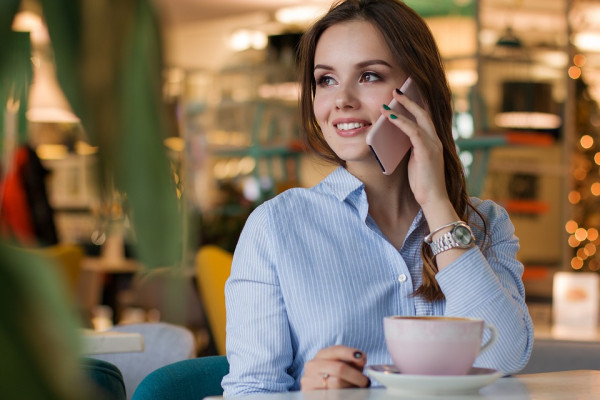 Woman speaking on a mobile phone over coffee