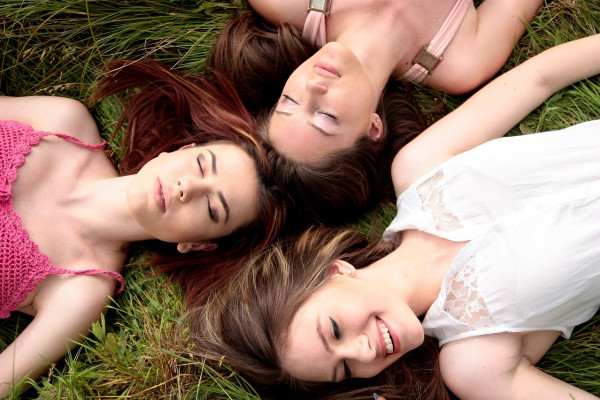 A group of female friends laying together in a field