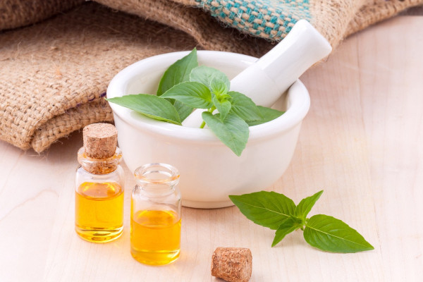 Mortar and pestle with herbs and bottles