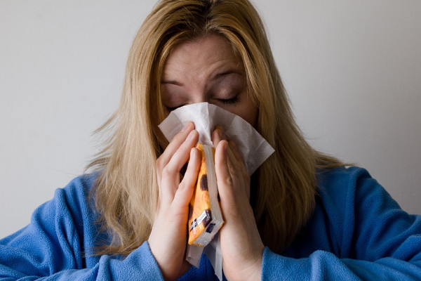 A woman blowing her nose