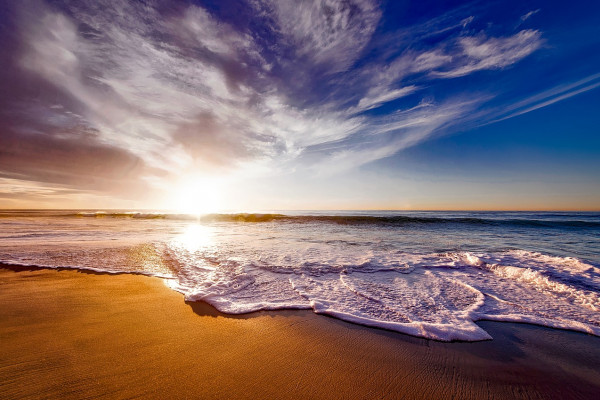 A tropical beach with the sun setting in the distance