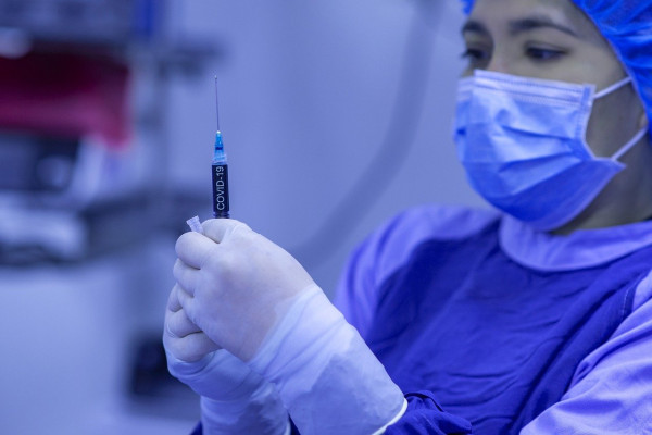 A healthcare worker preparing a needle.