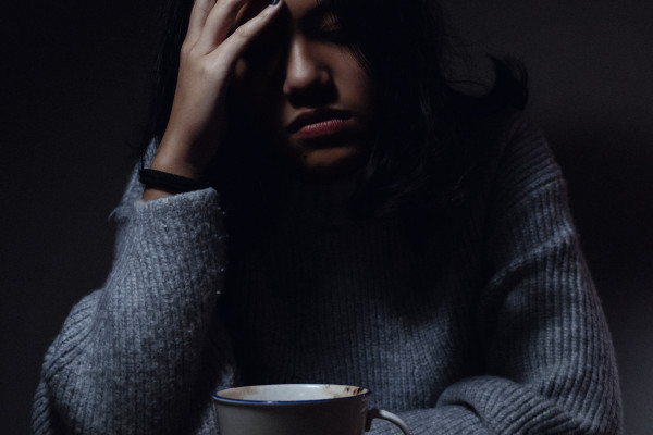 a woman sitting at table, in pain