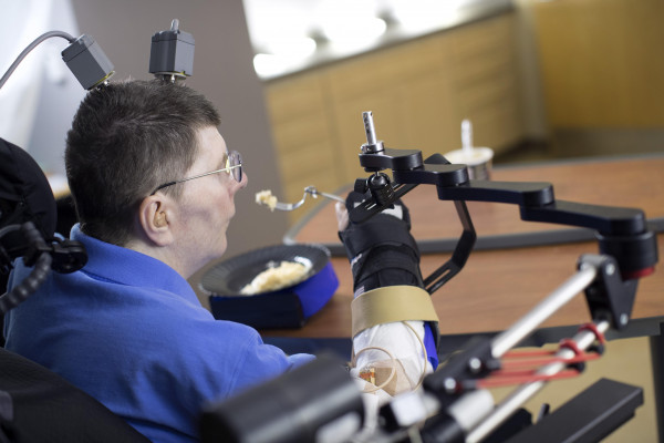 A brain-computer-interface helps a paralysed man to feed himself for the first time in 8 years.