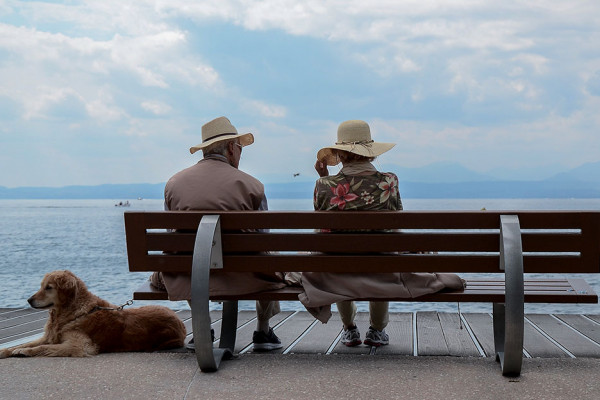 Two people on a bench by the sea
