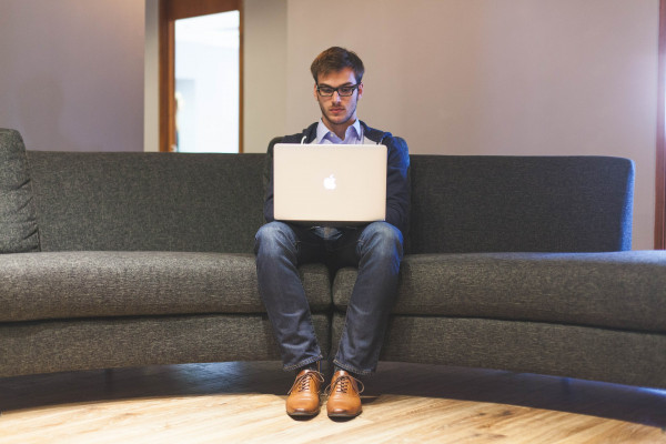 Man sitting with laptop on his lap