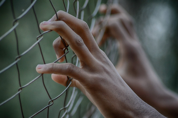 Hands on a fence
