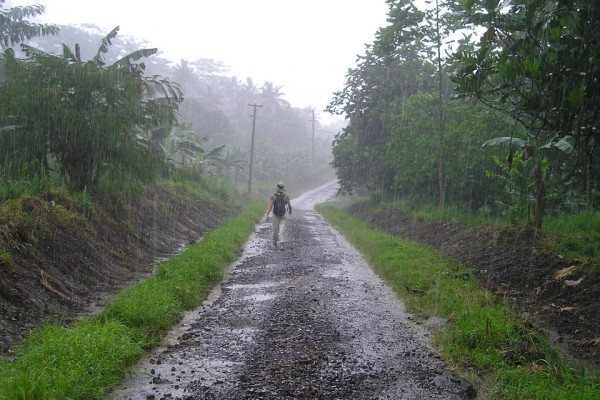 A person walking along a dirt track in the rain