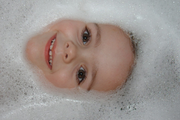 Face surrounded by bubbles in a bath