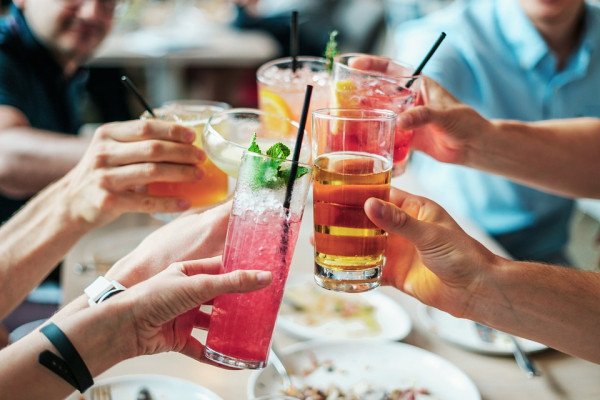 Group of alcoholic drinks held up by group