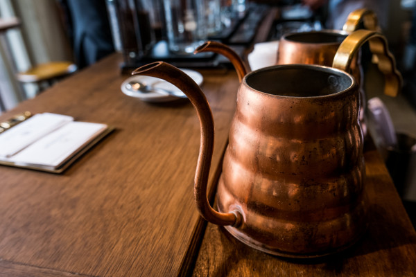 Two brass vessels on a wooden table