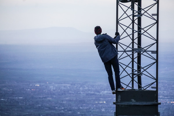 A man hangs from a 5G mast