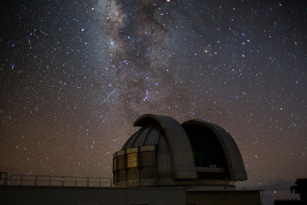 A large astronomical telescope against a dark starry sky.