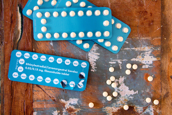Image of contraceptive pills and packets on a wooden table