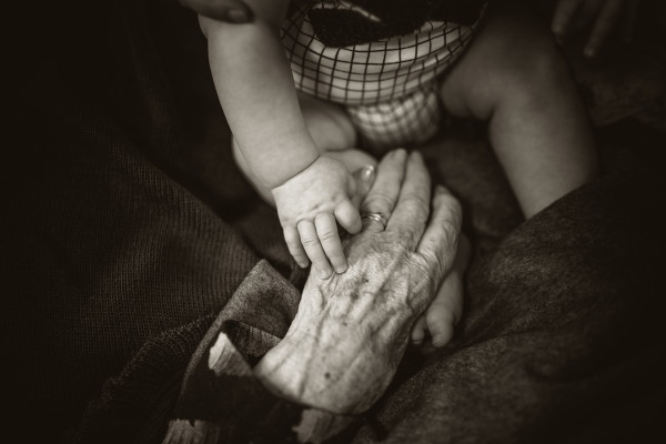 Young and old hands touching