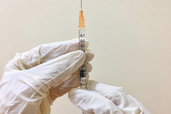 A vaccine being prepared by gloved hands