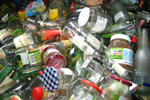 Empty glass bottles and jars in a pile for recycling.