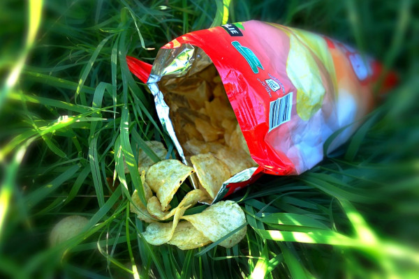 An open packet of crisps on grass