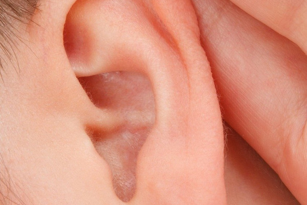 a close up of someone with their hand to their ear, trying to listen