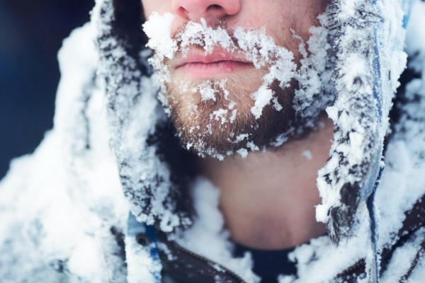 A bearded man with a winter coat covered in ice.