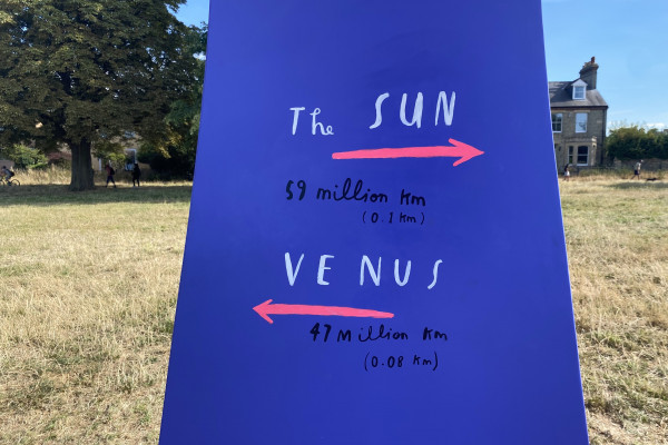 Purple sign saying the distance to the Sun and Venus on the "Our Place in Space" trail