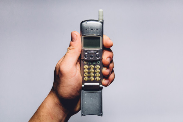 Image of a hand holding an old mobile phone