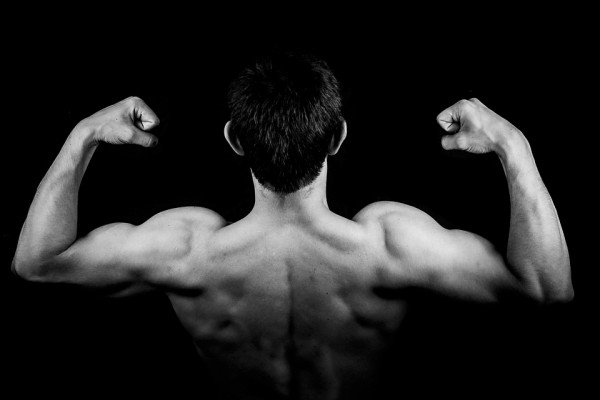 The picture shows a man flexing his back and shoulder muscles.