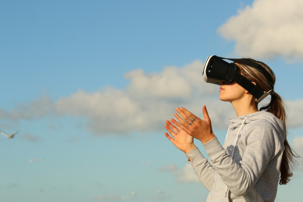 A woman gaming outdoors with a VR headset
