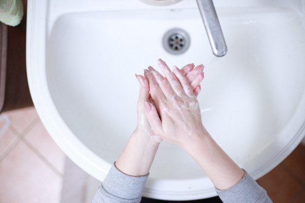 Washing hands under running water at a sink
