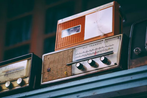 Some vintage radios sitting on a shelf