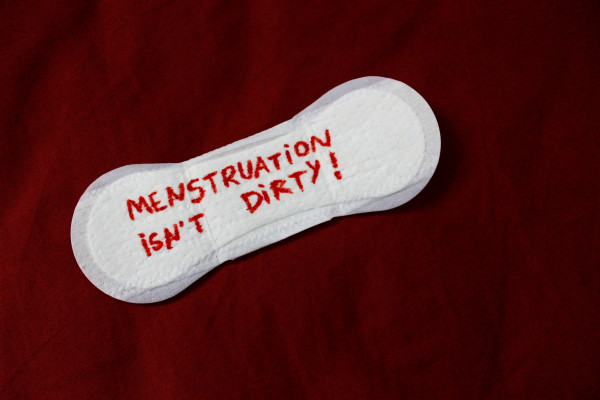 an image of a menstrual pad with text on it, on a red background