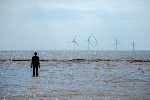 Antony Gormley "Another Place" exhibition on Crosby beach with Burbo bank wind farm in the background