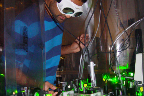 Dr Dhiren Kara adjusting the laser system used to measure the shape of the electron.