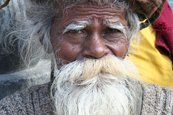 Old sadhu with white beard and coiled dreadlocks in Nepal.