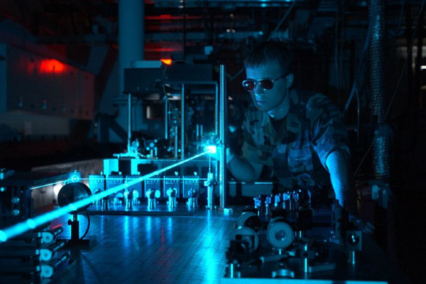 A military scientist operates a laser in a test environment. The Directorate conducts research on a variety of solid-state and chemical lasers.