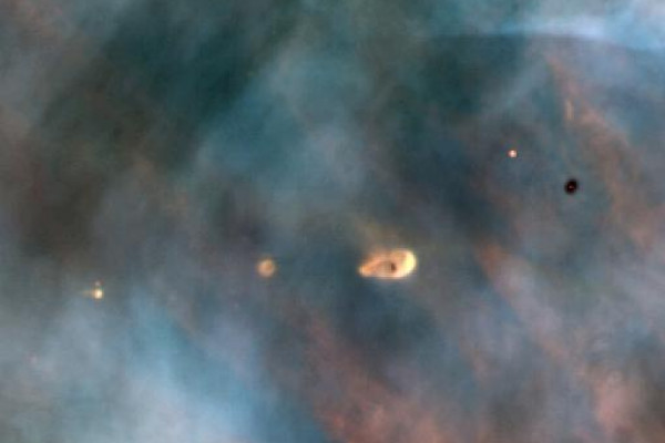  A Hubble Space Telescope view of a small portion of the Orion Nebula reveals five young stars. Four of the stars are surrounded by gas and dust trapped as the stars formed, but were left in orbit about the star. These are possibly protoplanetary...