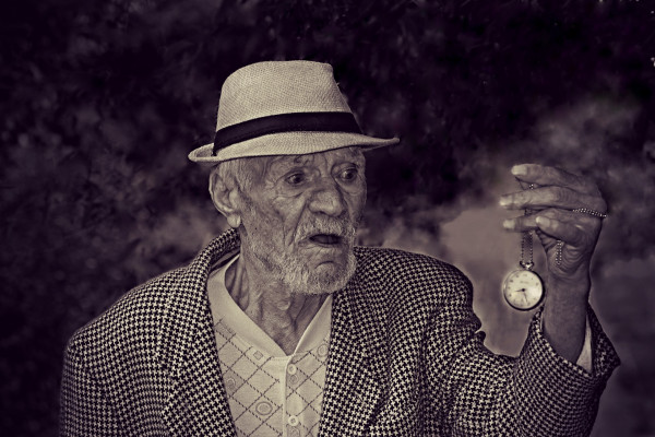 Elderly man holding a watch