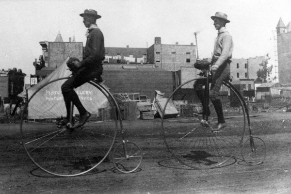 Two men ride penny-farthings in Los Angeles, California, 1886.